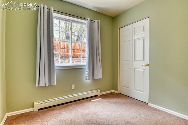 unfurnished bedroom featuring baseboards, baseboard heating, and carpet flooring