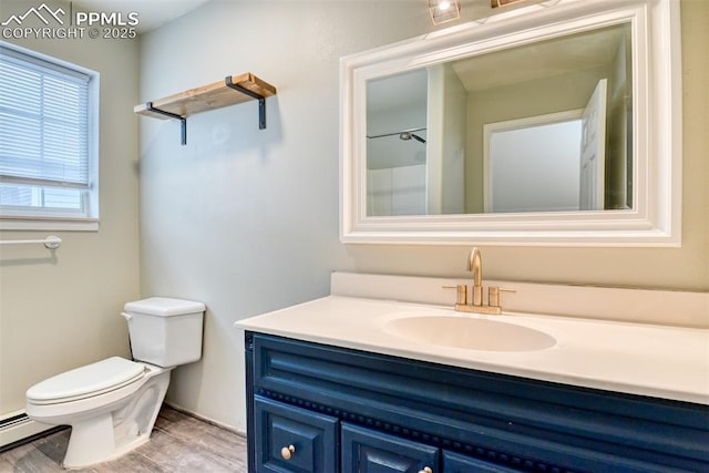 bathroom with baseboard heating, toilet, vanity, and wood finished floors
