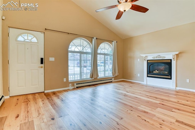 foyer entrance with hardwood / wood-style floors, a ceiling fan, baseboard heating, a glass covered fireplace, and high vaulted ceiling