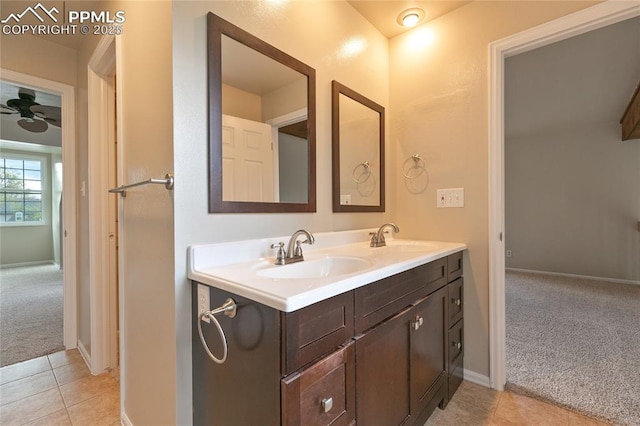 bathroom with tile patterned floors, double vanity, a ceiling fan, and baseboards
