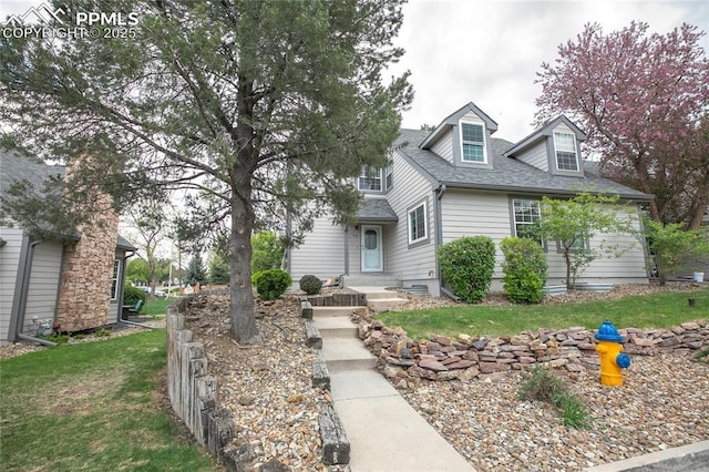 view of front of property featuring roof with shingles and a front lawn