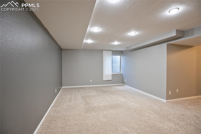 below grade area featuring a textured ceiling, carpet floors, baseboards, and recessed lighting