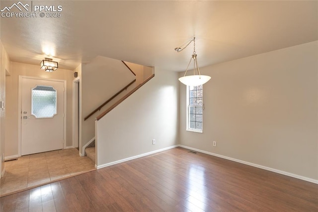 entryway featuring healthy amount of natural light, hardwood / wood-style floors, and stairway