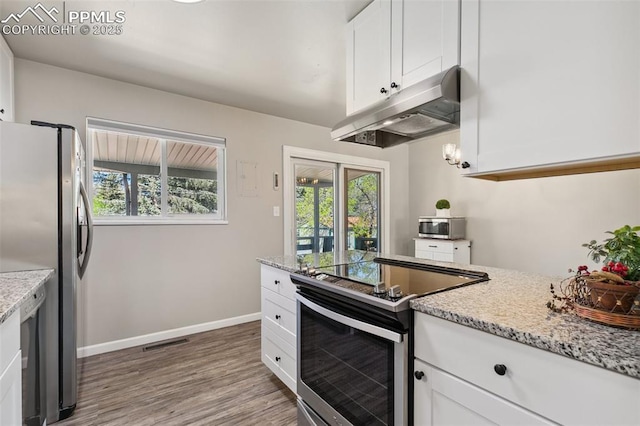 kitchen featuring stainless steel appliances, visible vents, under cabinet range hood, light wood-style flooring, and white cabinetry