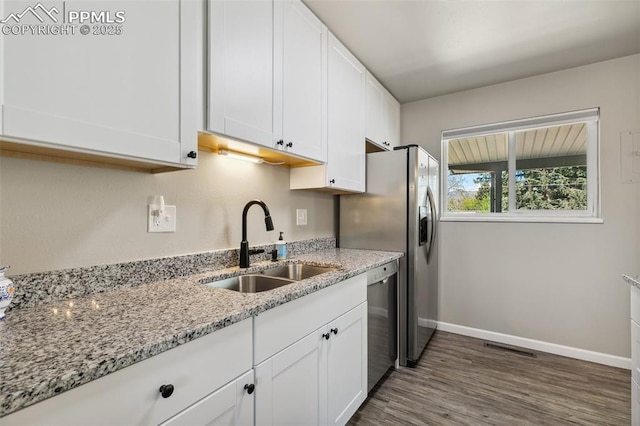 kitchen featuring a sink, dark wood-style flooring, white cabinetry, and dishwasher