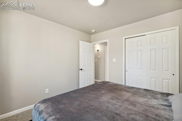 bedroom featuring baseboards, carpet flooring, and a closet