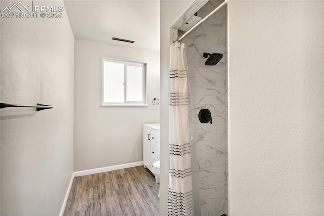 full bath with wood finished floors, visible vents, baseboards, and a tile shower