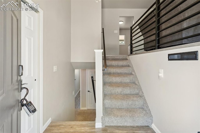 stairs with baseboards and wood finished floors