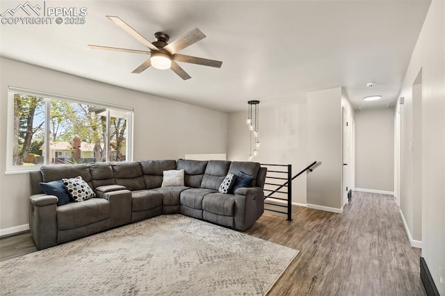 living area featuring baseboards, a ceiling fan, and wood finished floors
