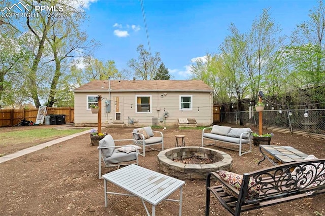 back of house featuring a fenced backyard and an outdoor fire pit