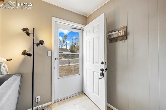 doorway with crown molding and baseboards