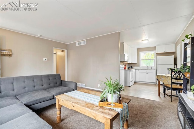 living room featuring visible vents and light wood-style flooring