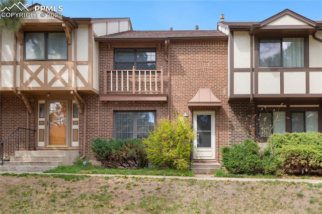 view of front of property featuring brick siding and stucco siding
