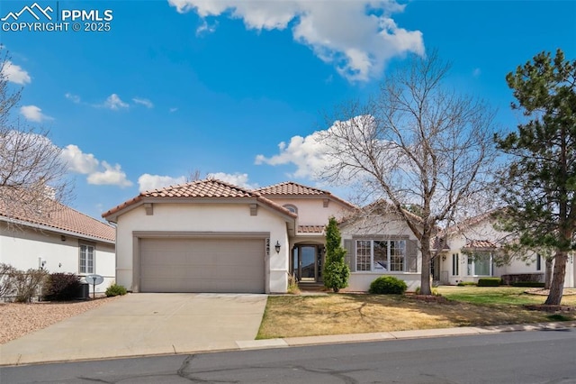mediterranean / spanish home featuring stucco siding, an attached garage, a tile roof, driveway, and a front yard