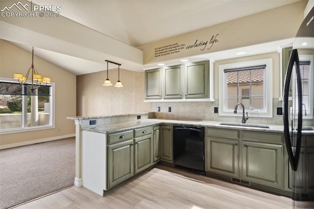 kitchen featuring a peninsula, a sink, black dishwasher, and a healthy amount of sunlight