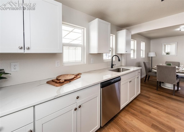 2204 Bonfoy Ave, Colorado Springs, CO 80909 - kitchen featuring a sink, light wood-style floors, dishwasher, white cabinetry, and light stone countertops