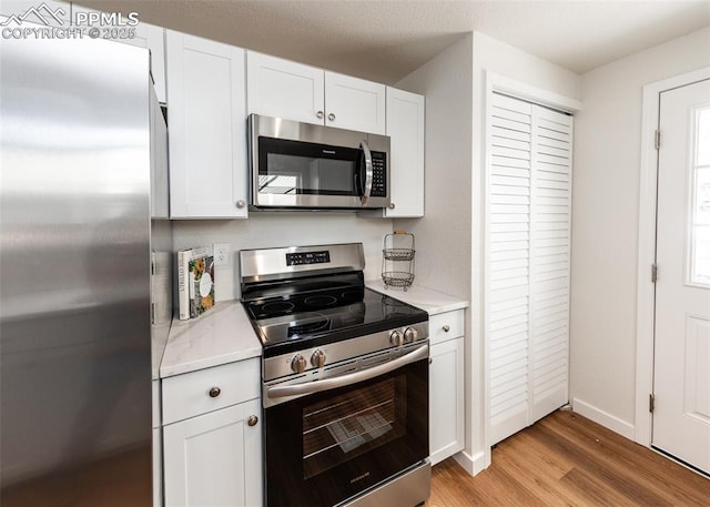 2204 Bonfoy Ave, Colorado Springs, CO 80909 - kitchen with stainless steel appliances, light wood-style flooring, baseboards, and white cabinetry