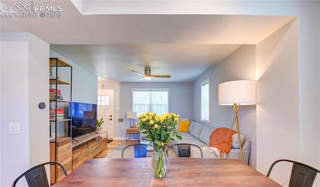 dining area with baseboards, wood finished floors, and ceiling fan
