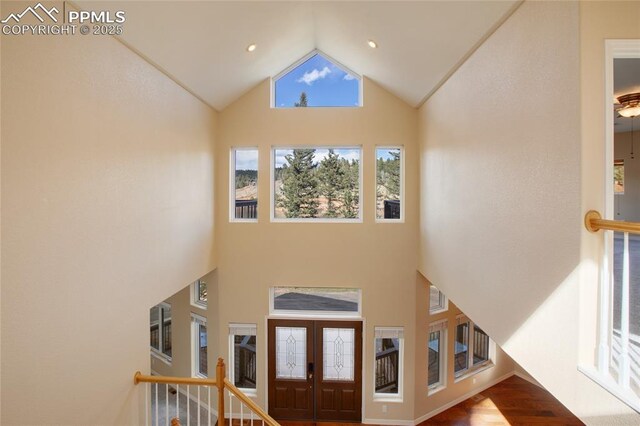 entrance foyer featuring wood finished floors and high vaulted ceiling