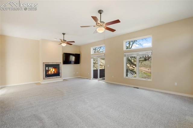 unfurnished living room with carpet floors, baseboards, and a tile fireplace