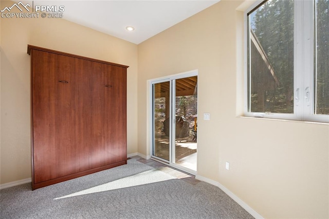 interior space featuring baseboards, carpet, recessed lighting, and a wealth of natural light