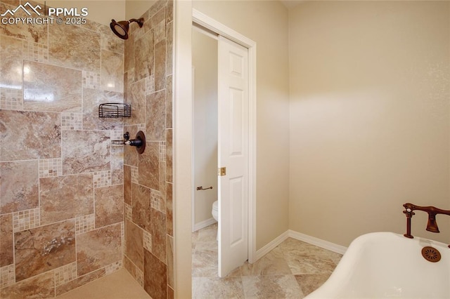 full bath featuring toilet, a freestanding tub, a tile shower, and baseboards