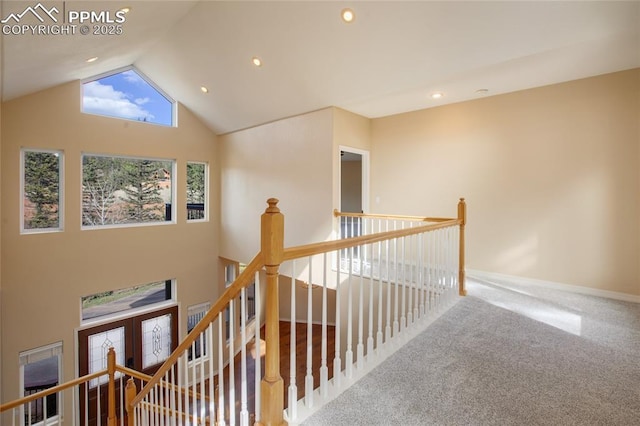 hall featuring recessed lighting, carpet, high vaulted ceiling, and an upstairs landing