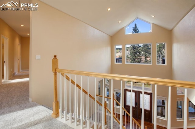 hallway with high vaulted ceiling, carpet, recessed lighting, an upstairs landing, and visible vents