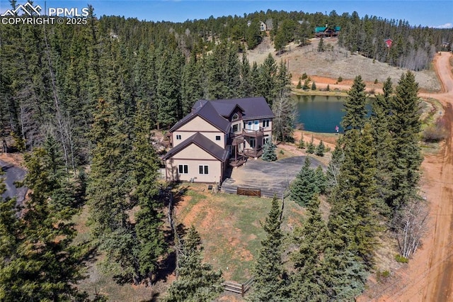 drone / aerial view featuring a water view and a wooded view