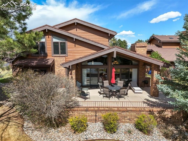 rear view of property with a patio area and brick siding