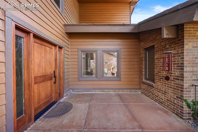 doorway to property with brick siding
