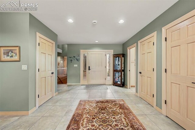 entryway with recessed lighting, light tile patterned flooring, and baseboards
