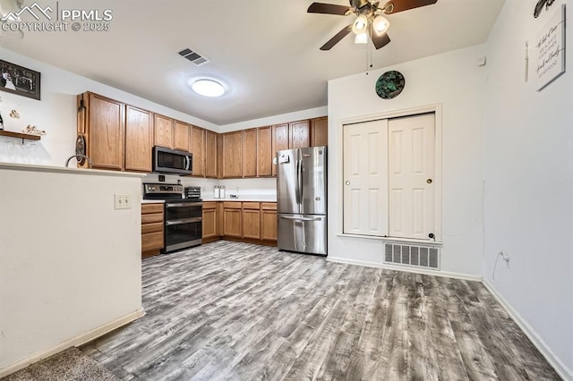 kitchen with ceiling fan, stainless steel appliances, wood finished floors, and visible vents