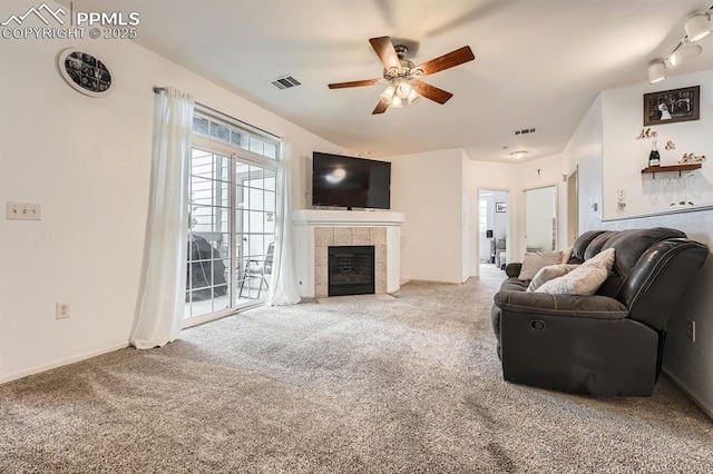 carpeted living area featuring visible vents, a ceiling fan, and a fireplace