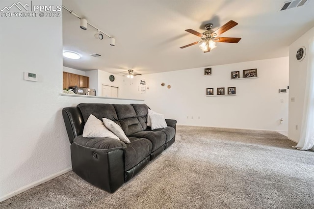 carpeted living area with a ceiling fan, baseboards, visible vents, and rail lighting