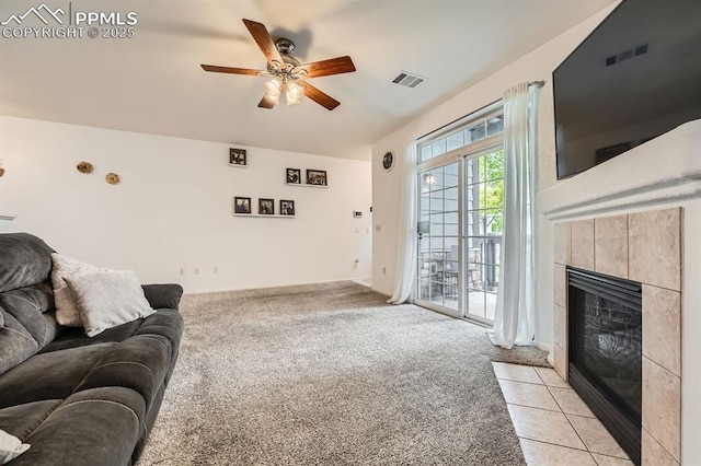 living room with visible vents, ceiling fan, light carpet, and a fireplace