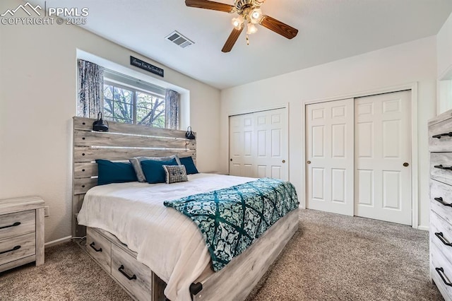 carpeted bedroom featuring multiple closets, a ceiling fan, and visible vents