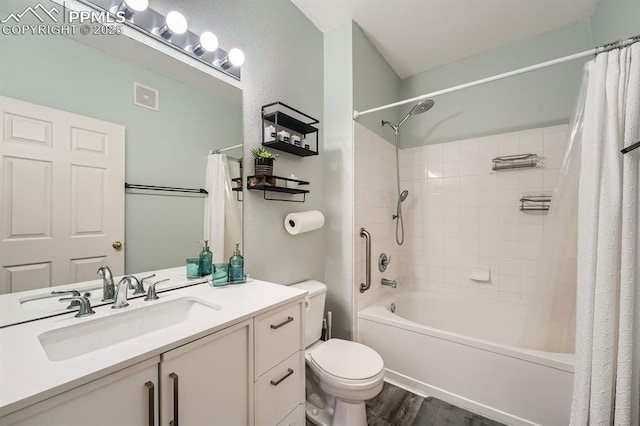 full bathroom with visible vents, vanity, wood finished floors, toilet, and shower / tub combo