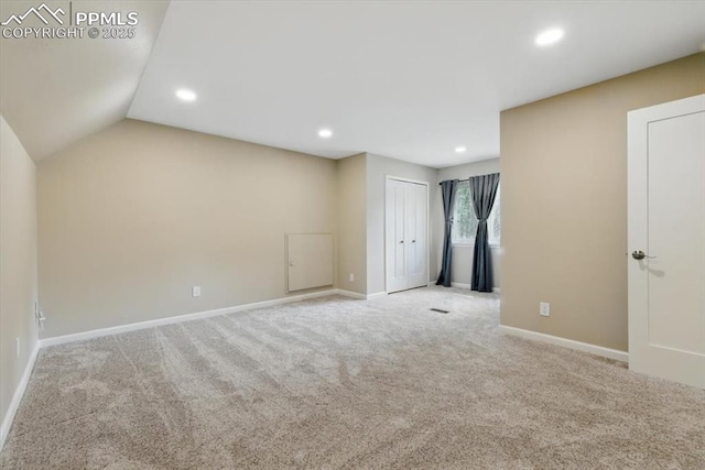 interior space featuring carpet floors, recessed lighting, baseboards, and vaulted ceiling