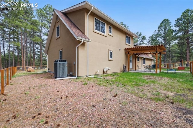 rear view of property with a pergola, cooling unit, a fenced backyard, stucco siding, and a patio area