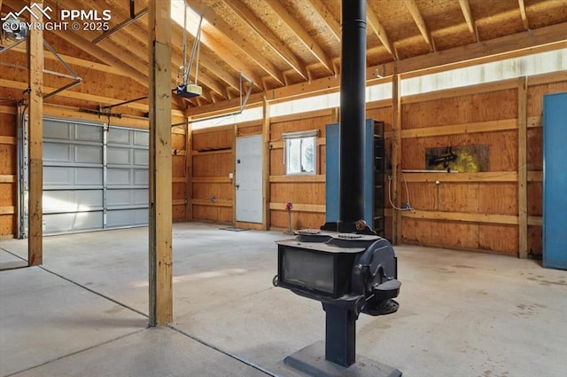garage with a garage door opener and a wood stove