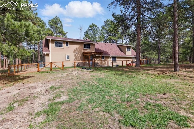 back of property with a fenced backyard, stucco siding, and a yard