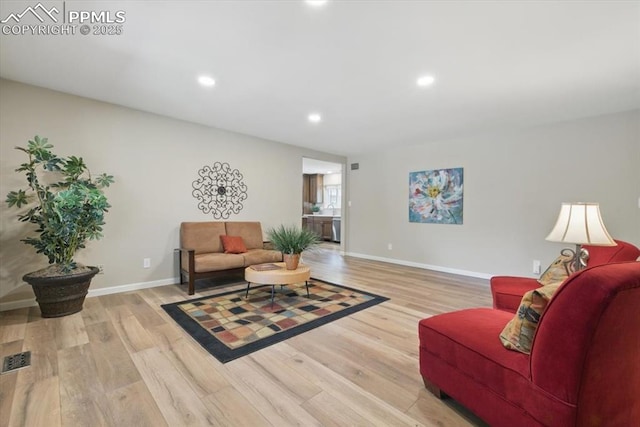 living area with baseboards, recessed lighting, light wood finished floors, and visible vents