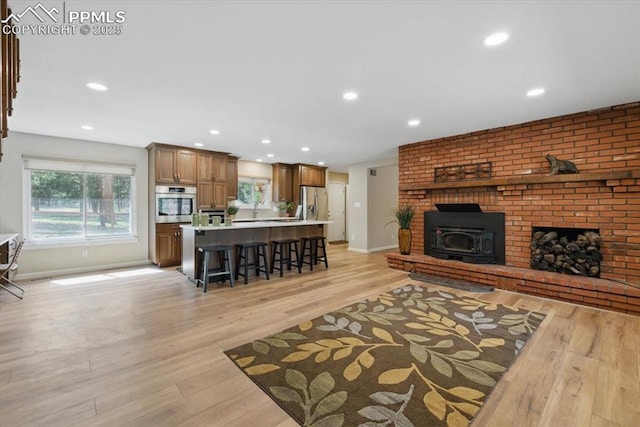living room with light wood-style floors, recessed lighting, and baseboards