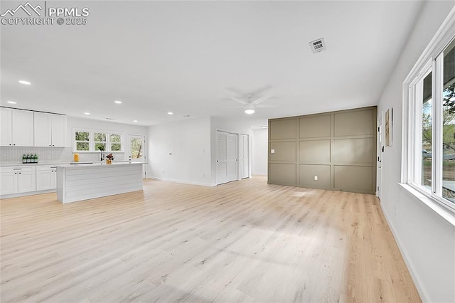 unfurnished living room with recessed lighting, a ceiling fan, visible vents, and light wood finished floors