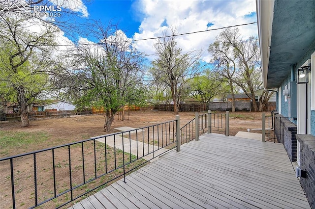wooden terrace with a fenced backyard