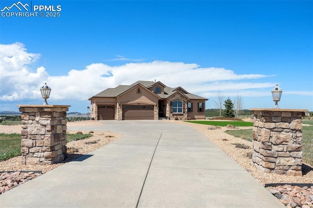 4908 Silver Nell Dr, Colorado Springs, CO 80908 - view of front of home featuring an attached garage, driveway, stucco siding, and stone siding