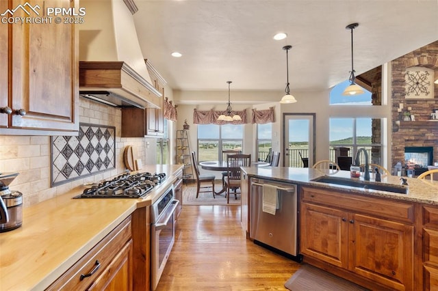 4908 Silver Nell Dr, Colorado Springs, CO 80908 - kitchen with decorative backsplash, premium range hood, a chandelier, a sink, and stainless steel appliances