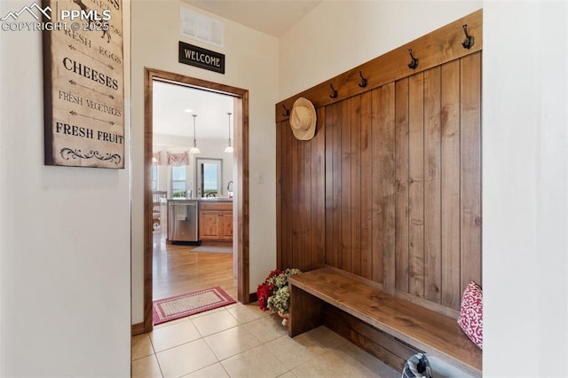 4908 Silver Nell Dr, Colorado Springs, CO 80908 - mudroom with visible vents, light tile patterned floors, and wooden walls