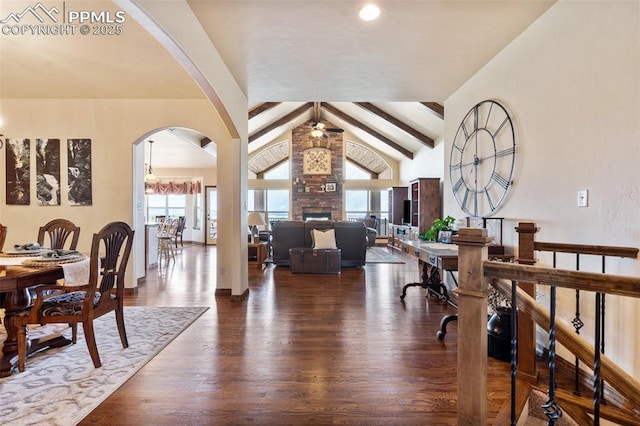 4908 Silver Nell Dr, Colorado Springs, CO 80908 - foyer featuring lofted ceiling with beams, a fireplace, arched walkways, a ceiling fan, and wood finished floors
